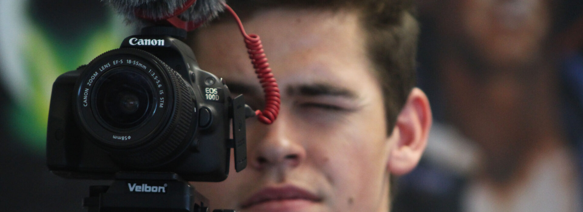 Photograph of a student looking through a camera.
