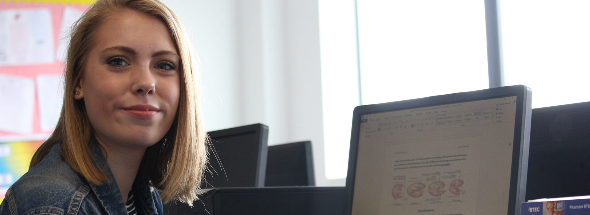 Photograph of a student working on her Health and Social Care assignment.