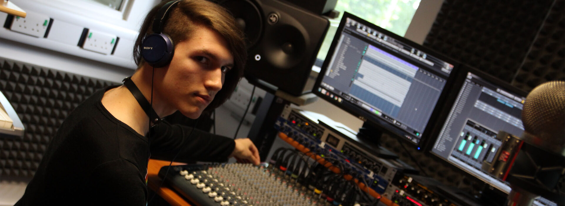 Photograph of a Music Technology student operating a mixer