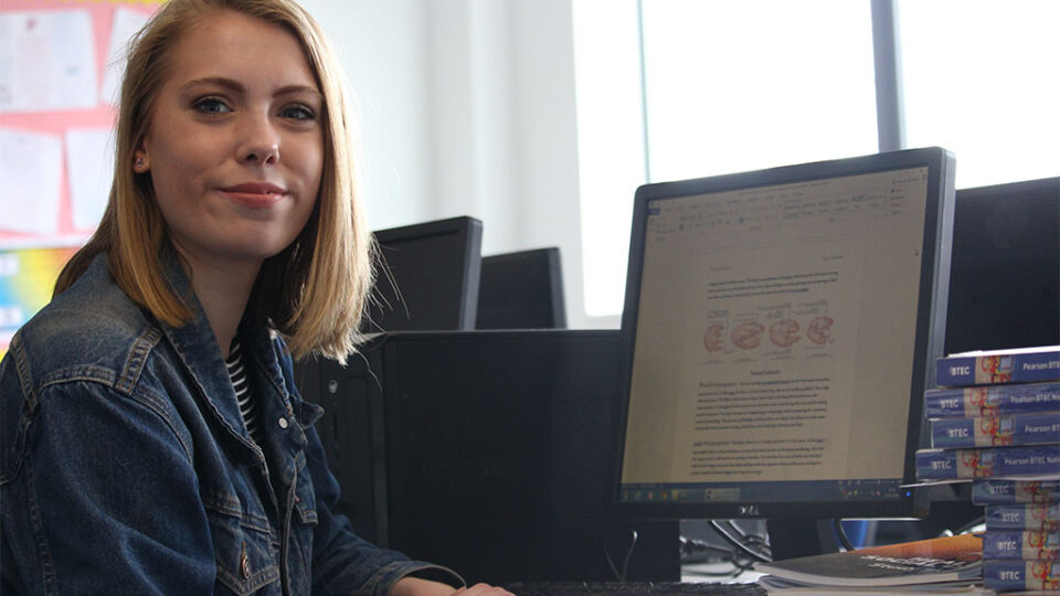 Photograph of a student working on her Health and Social care assignment.