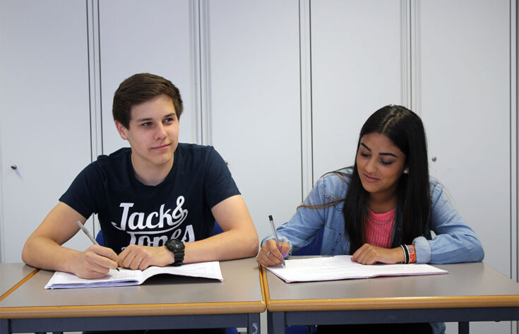 Photograph of students taking notes in a classroom.