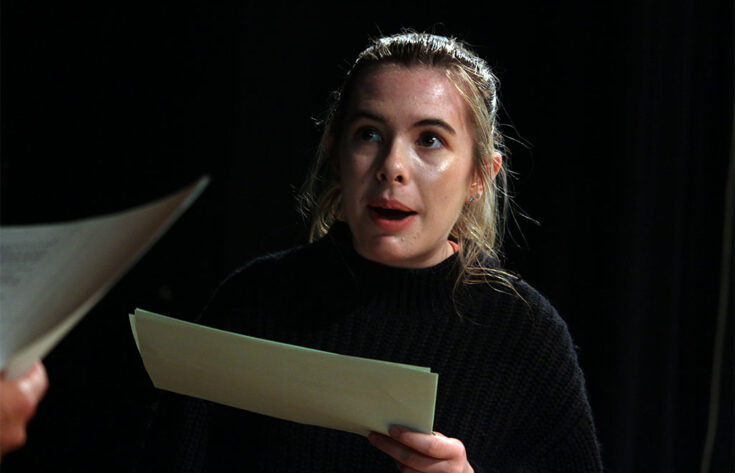 Photograph of a drama student reading a script